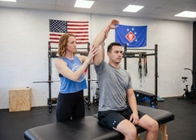  Patient working with a provider at a performance physical therapy clinic in Wilmington, NC, during a shoulder mobility assessment