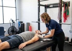 Patient receiving dry needling shoulder treatment at a performance physical therapy clinic in Wilmington, NC